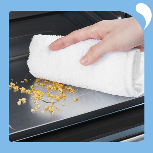 One hand holds a white cloth to wipe the crumbs