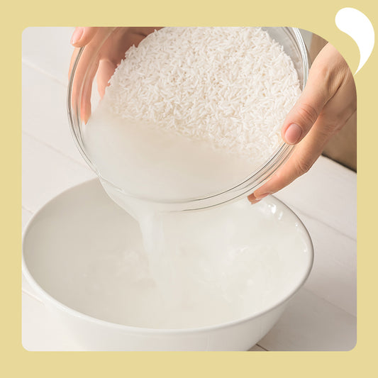 One hand holds the rice and pours out the rice water