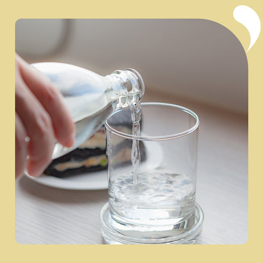 someone takes water and pours it into a glass