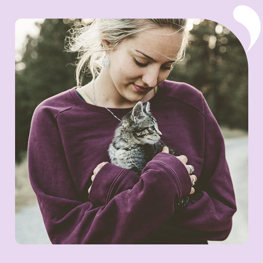 a woman tenderly holds the cat in her arms