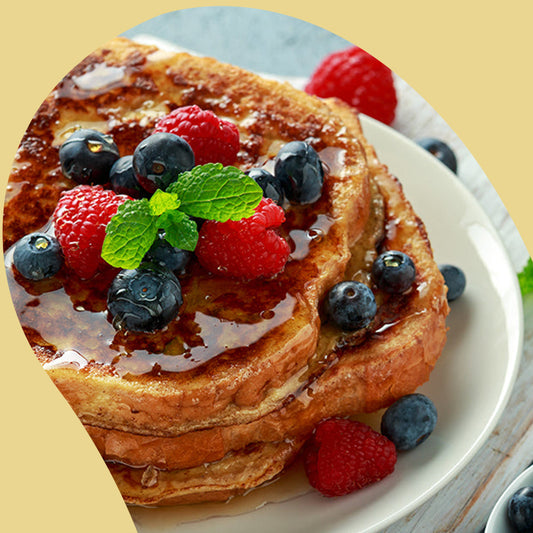 slices of french toast with blueberries strawberries and syrup on top