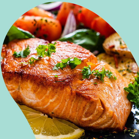 a baked salmon with a slice of lemon and tomatoes 