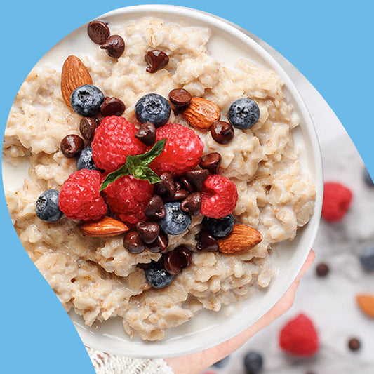 overhead view of a bowl of oatmeal with strawberries and blackberries on top