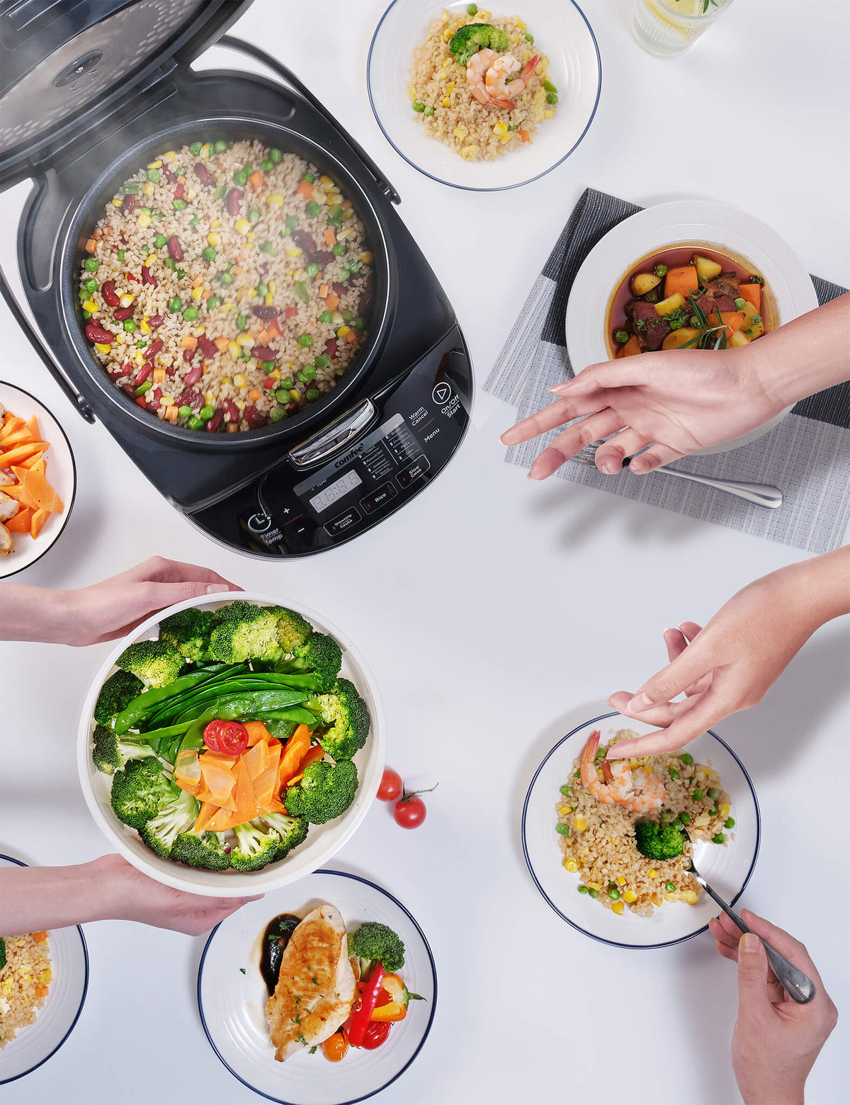 rice cooker with rice inside surrounded by various meals