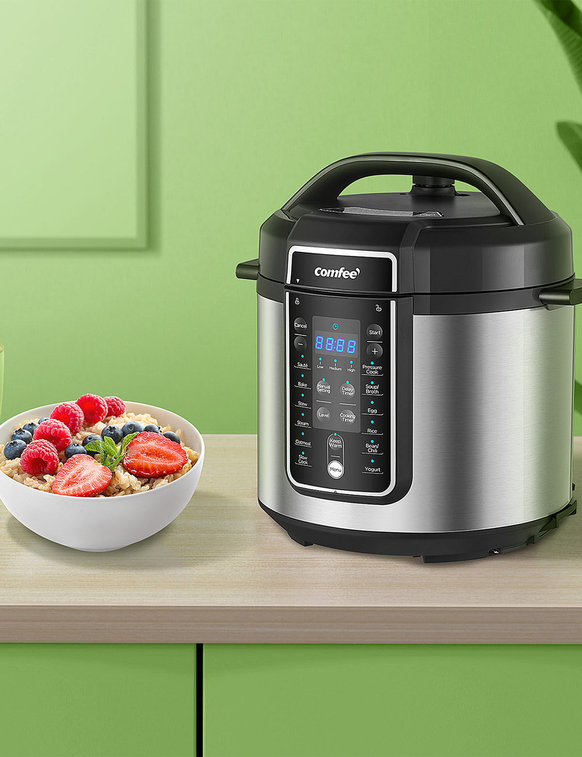 stainless steel pressure cooker on a cabinet next to a bowl of oatmeal and strawberries and a cup of milk